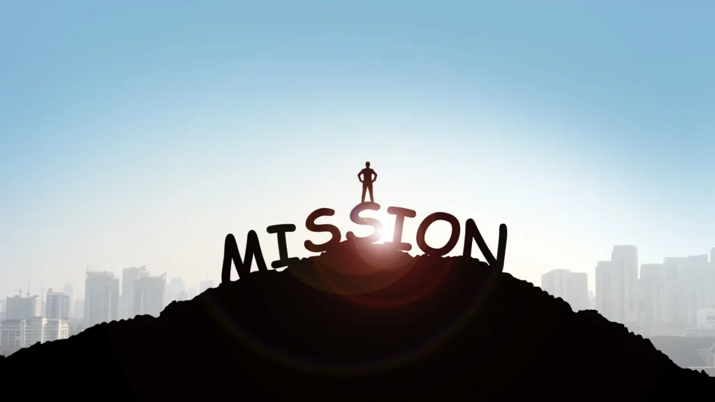 Au premier plan, une colline sur laquelle est inscrit le mot MISSION et sur lequel un homme se tiens debout face au soleil levant ainsi qu'à la ville.