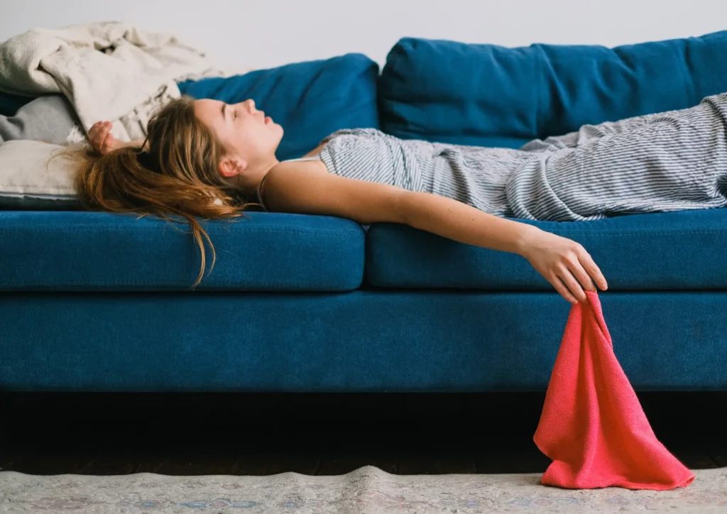 Une femme profitant de sa vie privée pour flâner sur le canapé de son appartement.